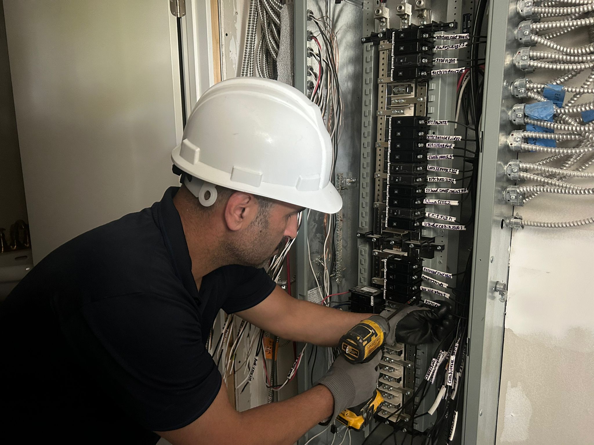 Electricians terminating a service pedestal at a commercial unit under construction